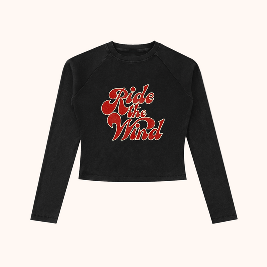 Black long-sleeve crop top with 'Ride the Wind' text in red
